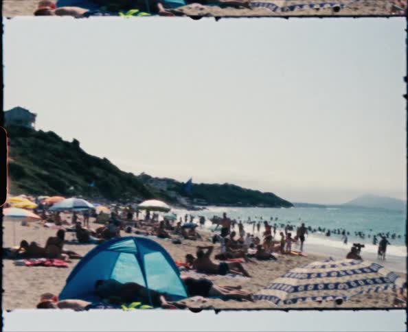 A beach full of sunbathers and umbrellas