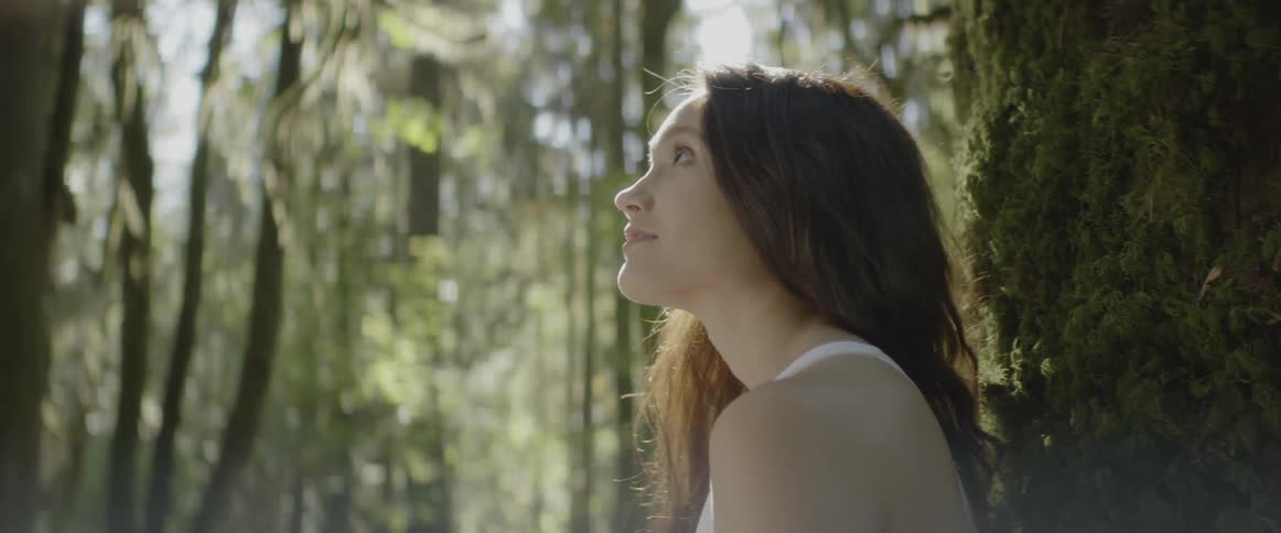 A woman smiles in the forest