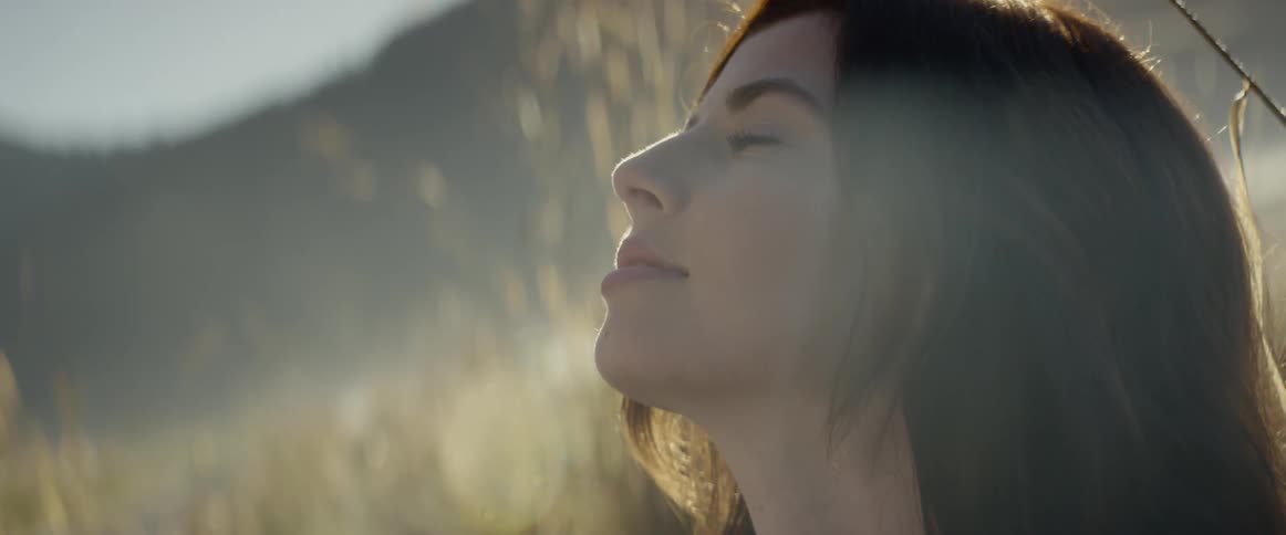 A woman looks up at the sky on a sunny day
