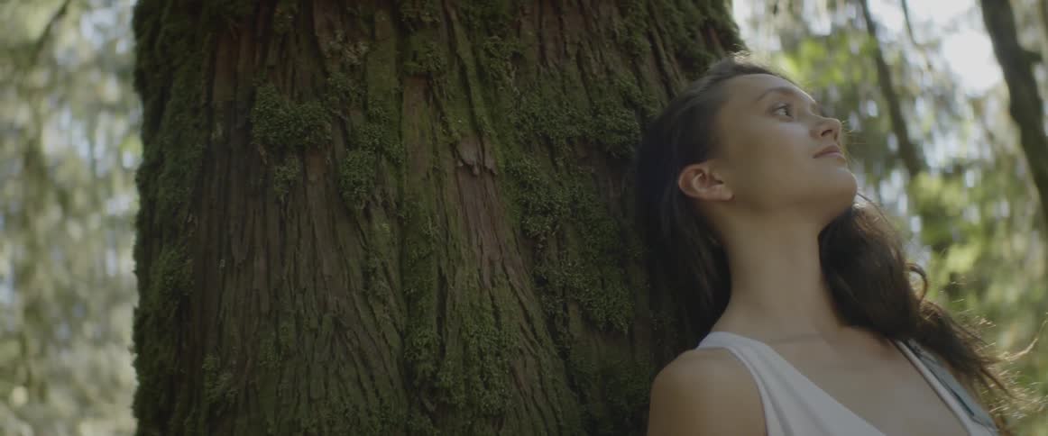 A woman leaning on a tree