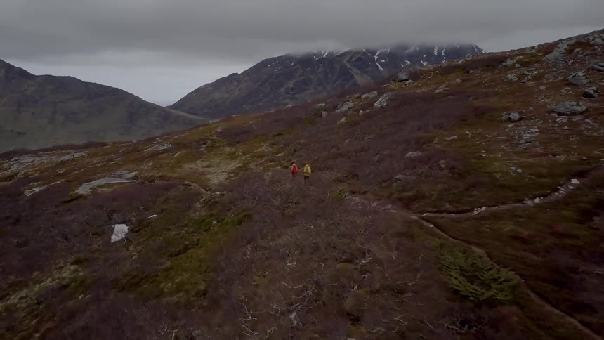 Two people are hiking up the mountain side