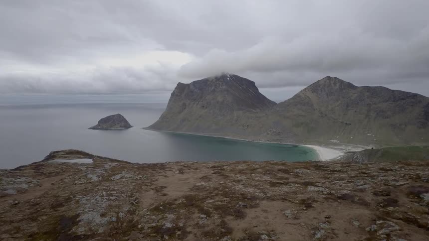 The waves slowly hit the shore by the mountains