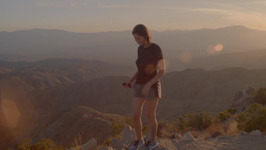 A woman watches sunset in Joshua Tree