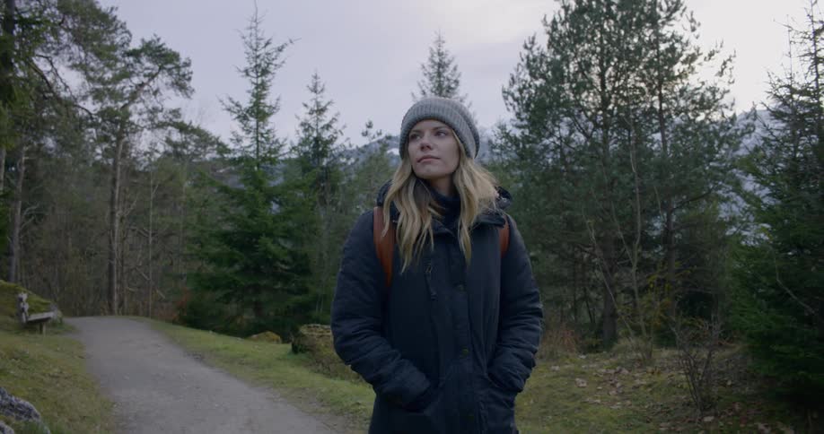 A woman walks a path through the woods