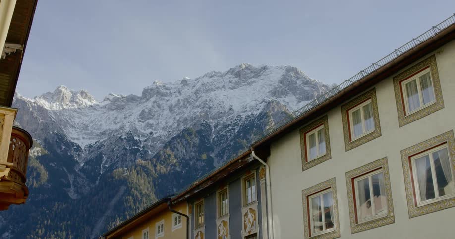 A mountain looms behind a row of housing structures