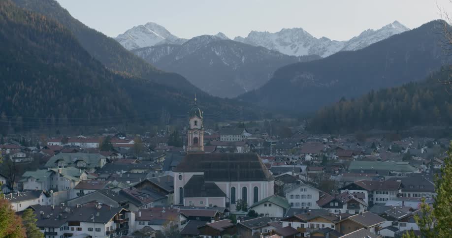 An aerial view of a neighborhood by the mountains is displayed