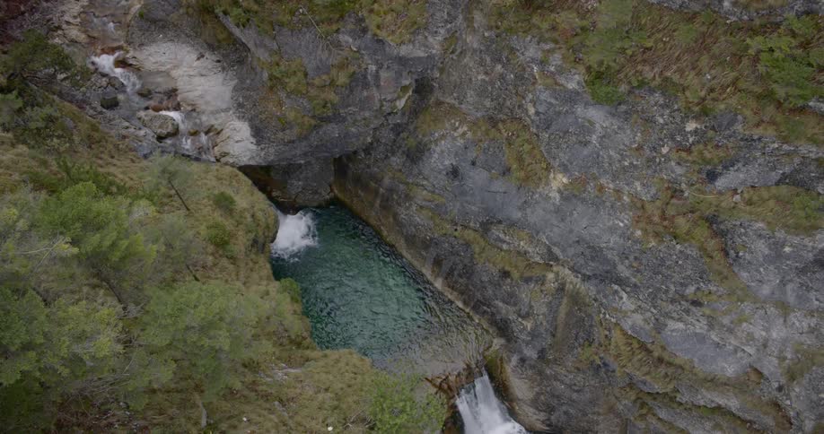 The water pours from the stream towards the waterfall