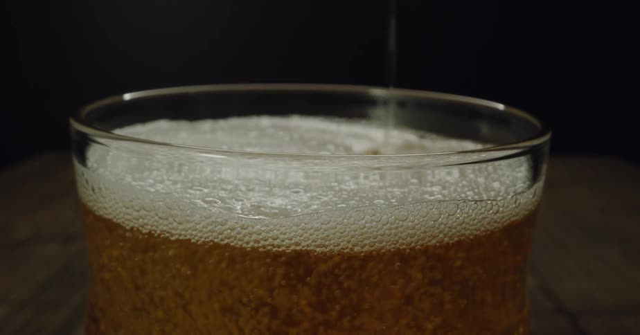 A closeup view of a beer pouring on a glass