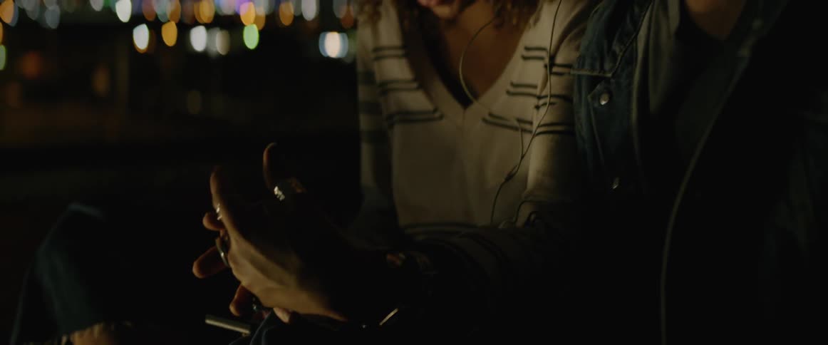 A man and a woman laugh while holding hands