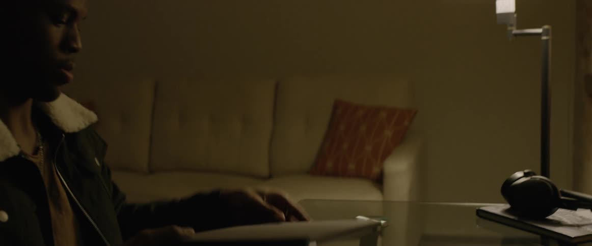A man sits at a desk and opens up his laptop