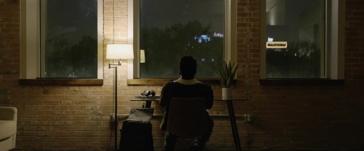 Black sitting at table relaxes in a room at night
