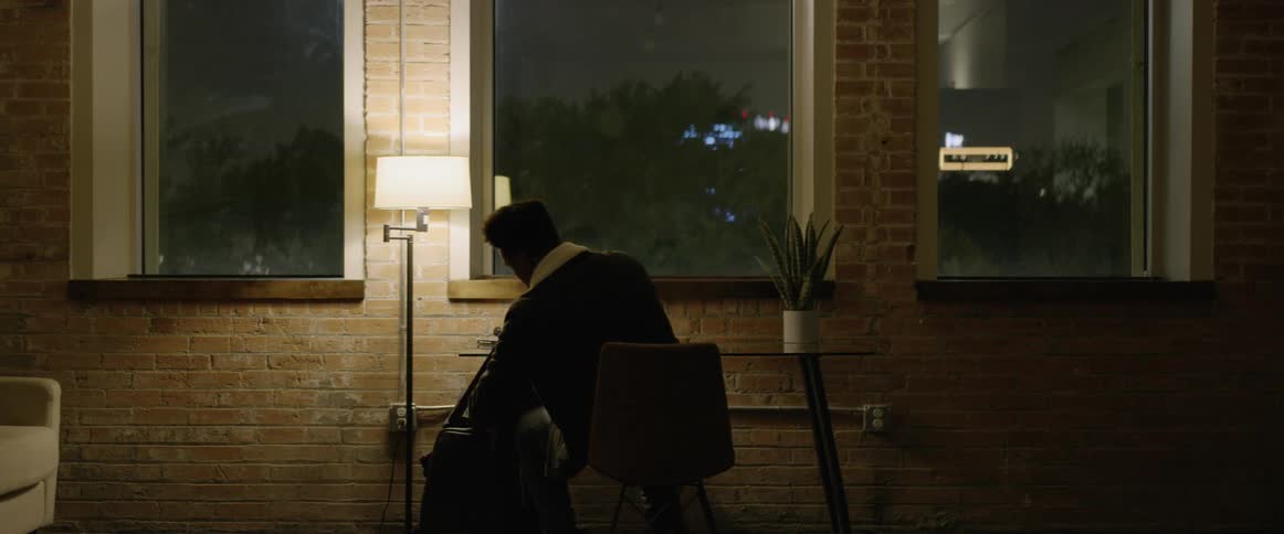 Man sitting at desk and packing a bag before walking away