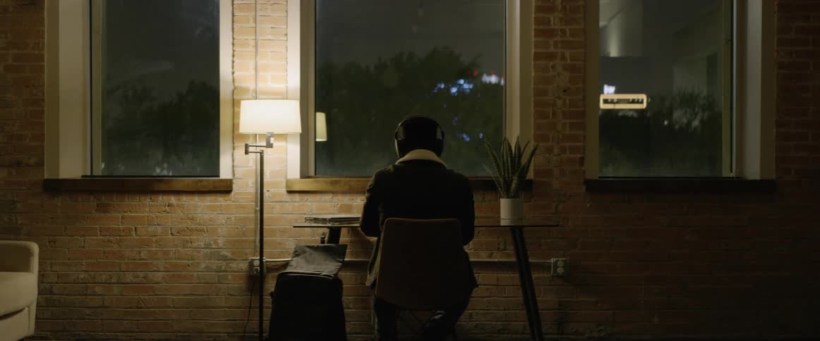 A person sits at a table with headphones on