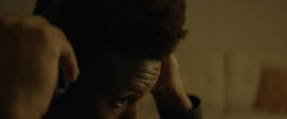 Black man wears headphones indoors