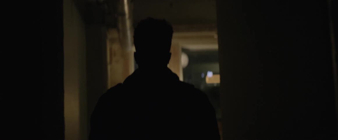 Black man walks into the room at night