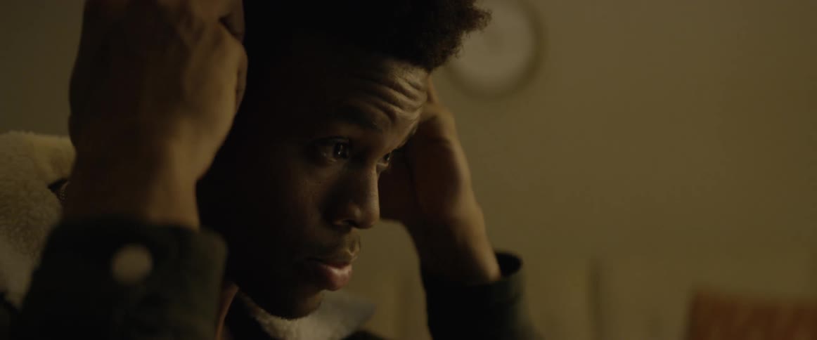 A black man puts on a pair of headphones