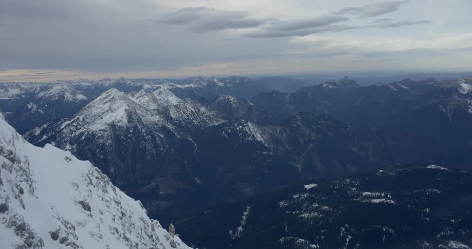 A mountain with other mountains and the sky in the background