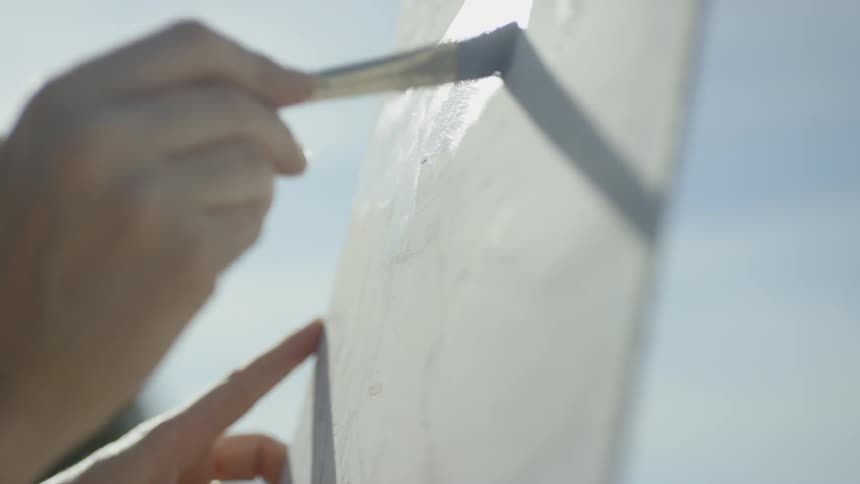 A hand of a painter painting