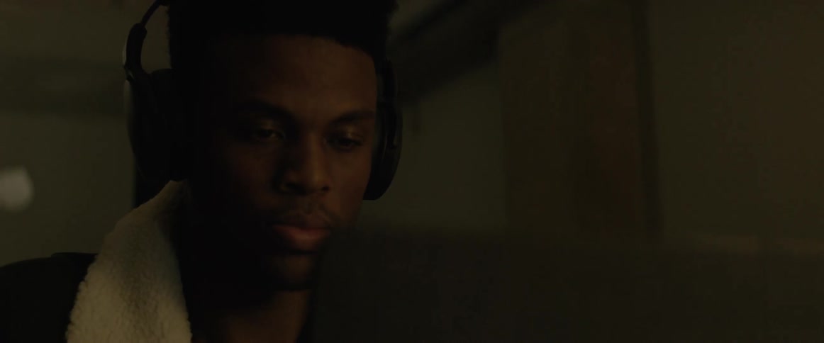 A black man listening with headphone