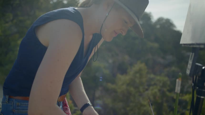 A female artist wipes a paint tray clean