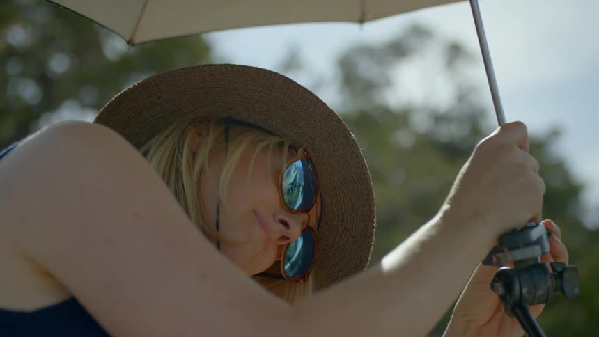 A woman puts an umbrella into a stand