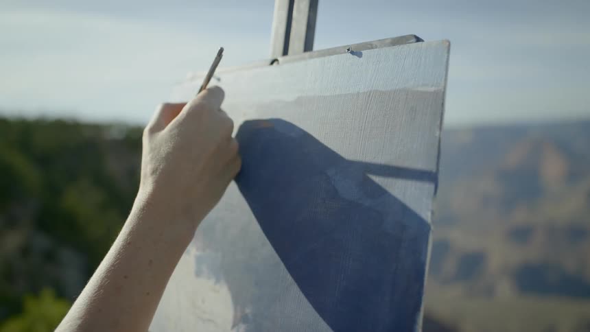 Someone starts painting on canvas