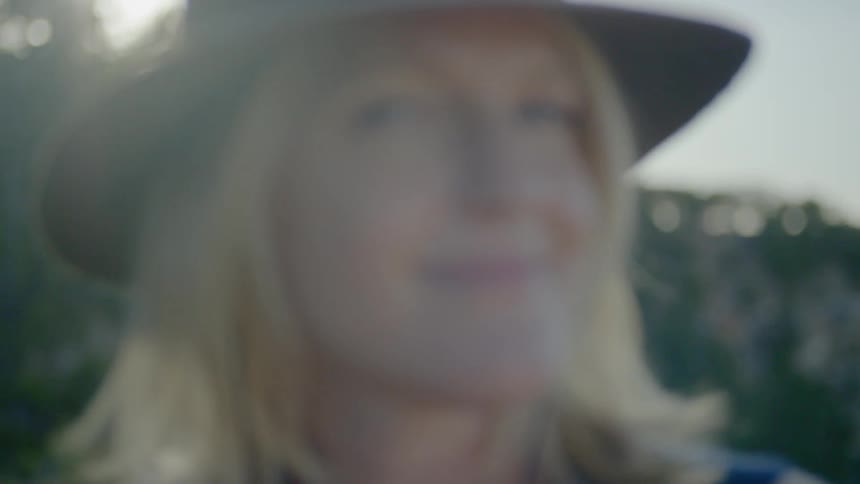 A blonde woman looks into the camera and smiles