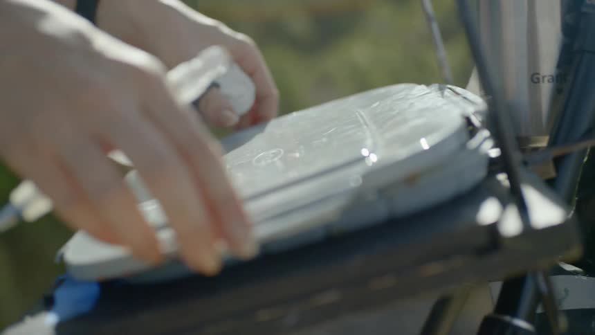 A smiling middle aged blonde haired caucasian woman puts a cover on a container