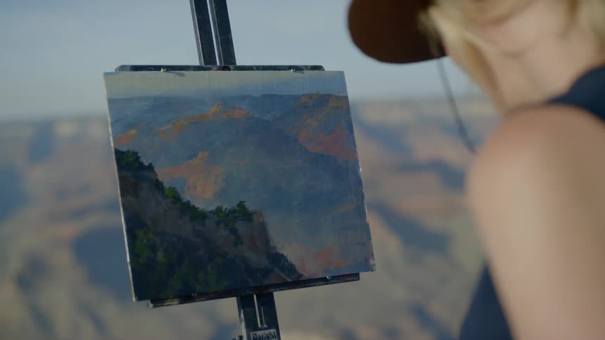 A woman is painting outdoors