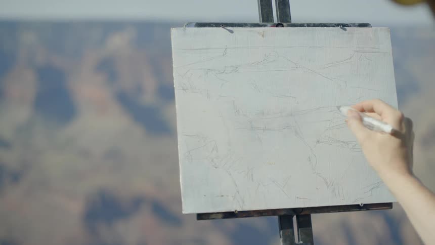 A woman sketches the mountains