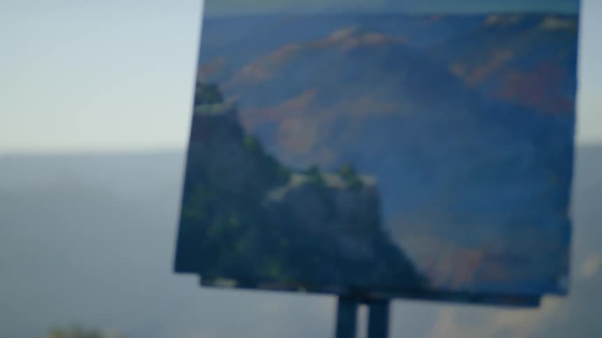 A painting on an easel at the top of a cliff