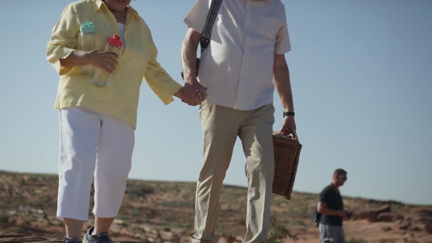 Two people walk over to set up a picnic