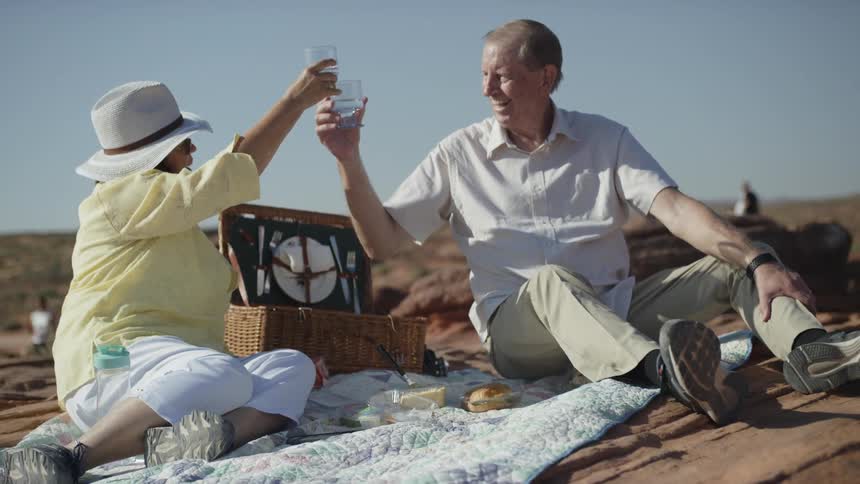 An old couple drink at middle of a desert