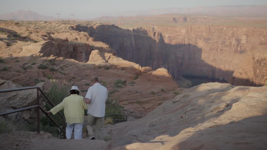 A man and woman walk down the stairs