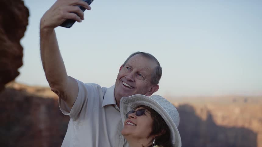 Older couple take selfie near canyon