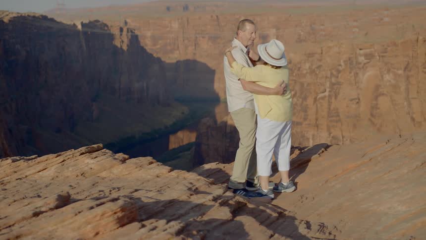 A man and woman dance on the edge of the grand canyon