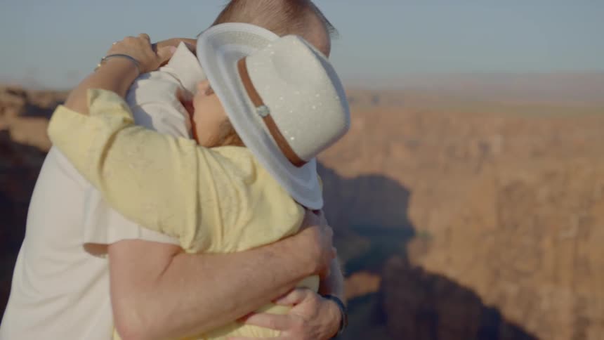 Woman wearing cowboy hat cuddles man in grand canyon
