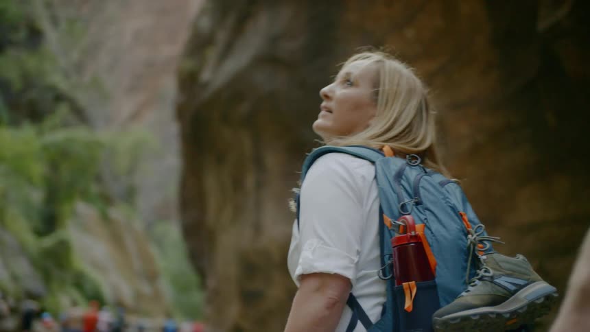 A woman walks through the water as she hikes in a big group