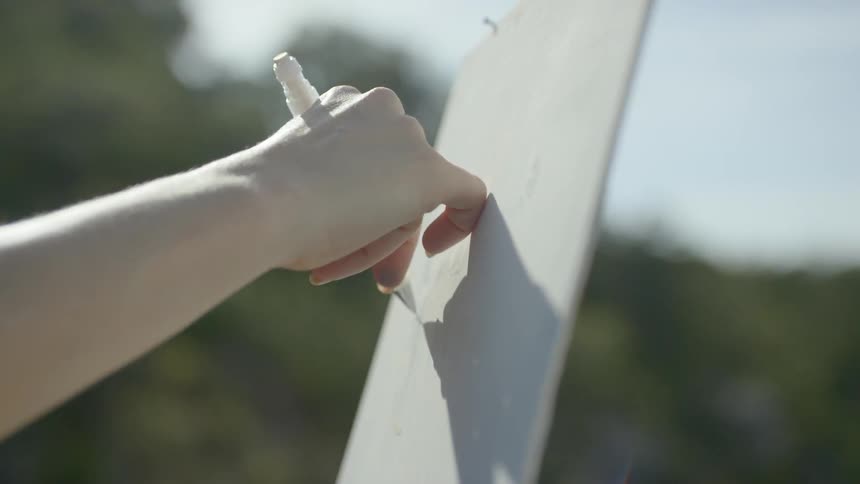 A person drawing on a board outdoors