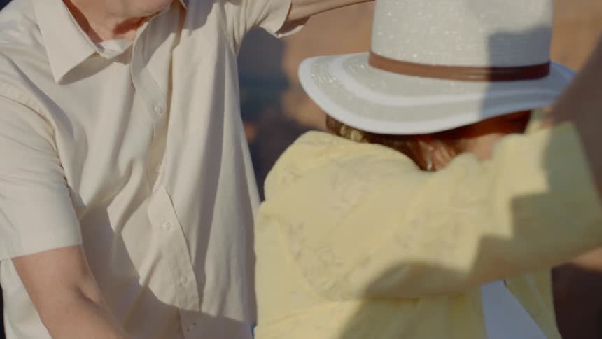 A man and woman dance outside on a hillside