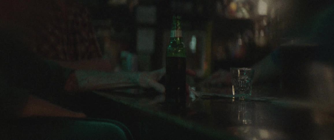 A person is sitting at a bar drinking