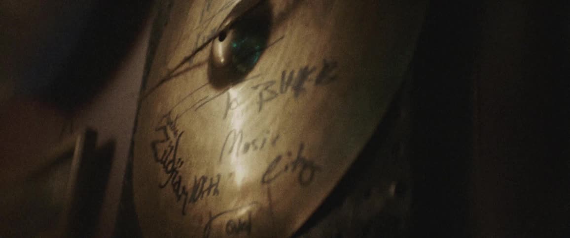 A signed cymbal hangs on a wall