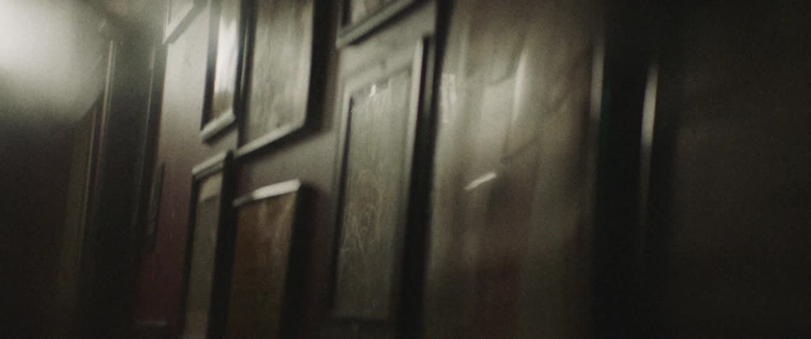A room with multiple pictures in frames hanged on the wall