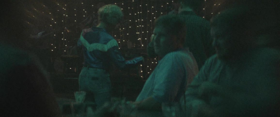 A man and woman square dancing while a band plays on stage