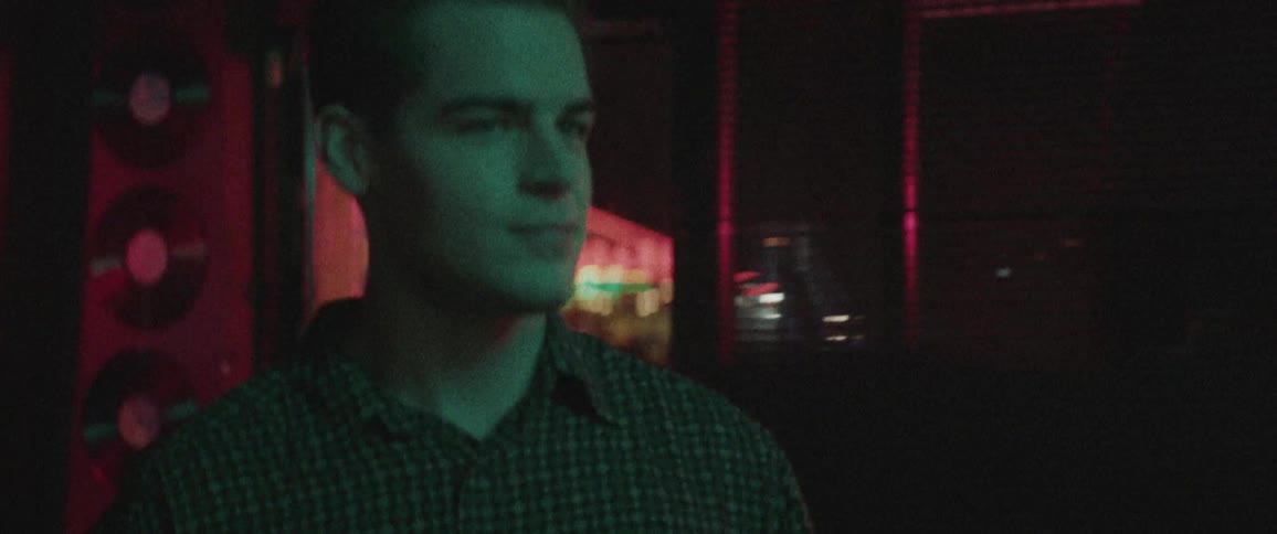 A white man walks into a darkened room