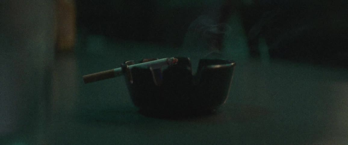 A cigarette burns in an ashtray