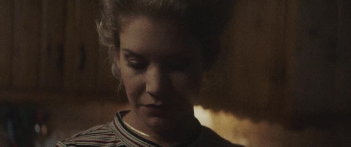 A woman is indoors looking down