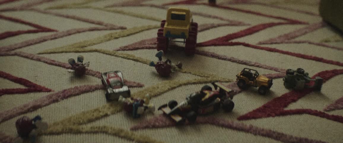 Toy cars lay on a rug