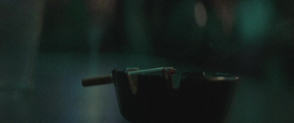 A cigarette burns on an ash tray