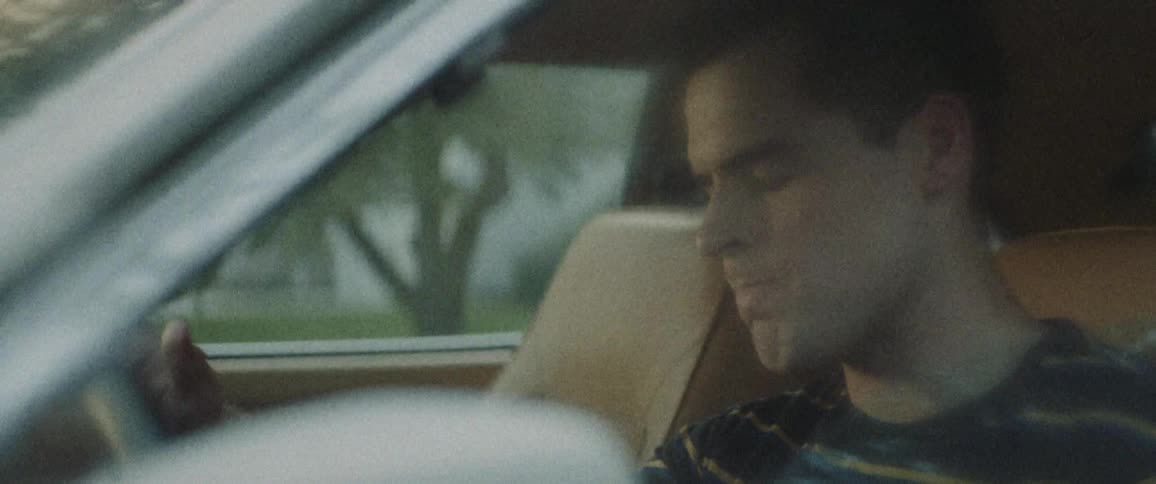 A man is sitting in the car looking down